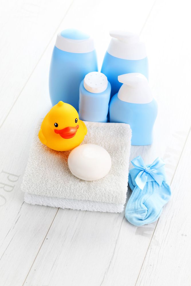 baby bath supplies set out on the floor, soap, wash clothes and rubber duckie are ready for bathtime with baby