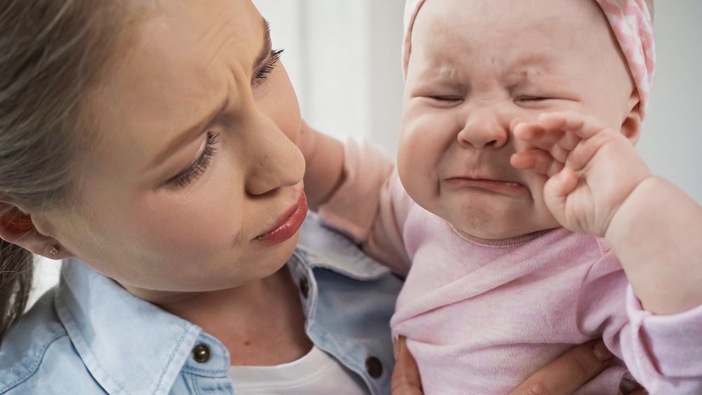 Concerned mom looking at fussy baby