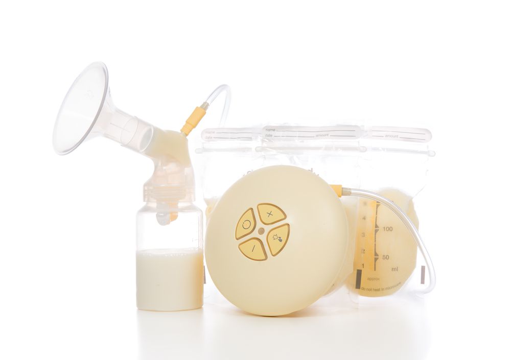 New compact electric breast pump to increase milk supply for breastfeeding mother and child feeding bottle with breastmilk isolated on white background