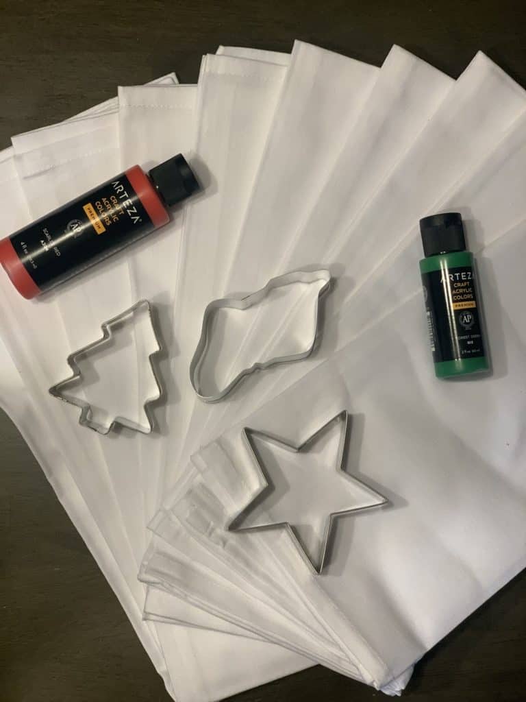 Materials for Toddler DIY Christmas Tea Towels with tea towels, cookie cutters, and fabric paint