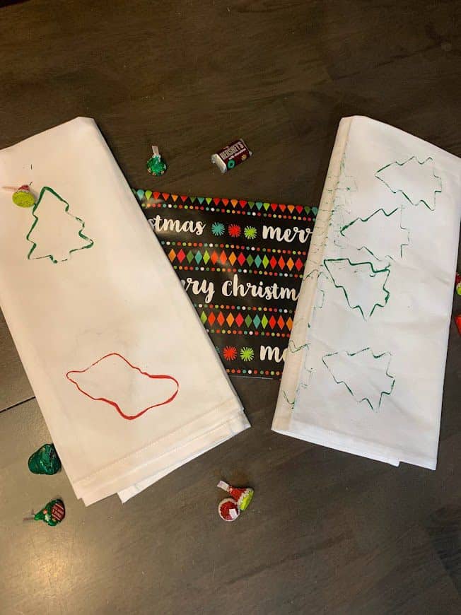 Christmas tea towels toddlers can make with Merry Christmas wrapping paper and Christmas candies